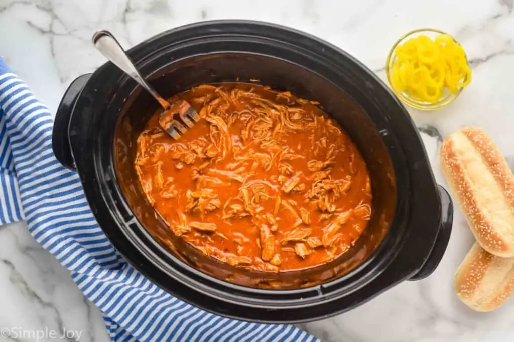 overhead view of a slow cooker full of shredded buffalo chicken