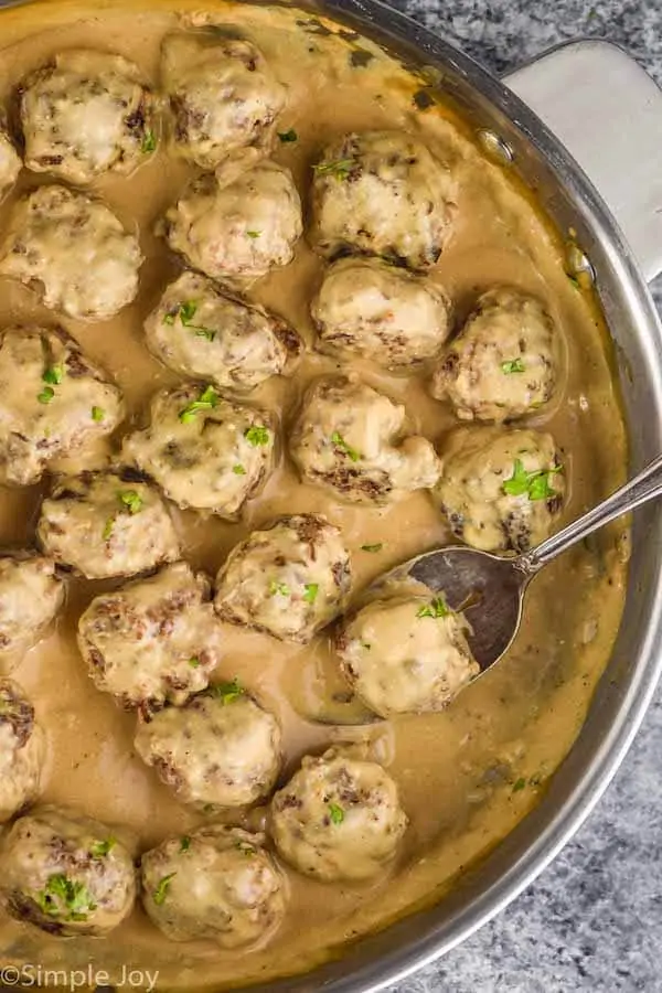 overhead of a pan of swedish meatballs in sauce garnished with parsley