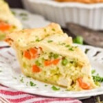 a piece of chicken pot pie on a white plate garnished with parsley - 11