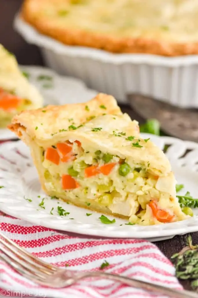 a piece of chicken pot pie on a white plate garnished with parsley