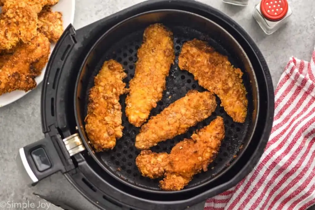 overhead view of breaded chicken tenders in an air fryer basket