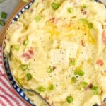 close up overhead of a bowl of colcannon with two pads of butter and diced scallions - 8
