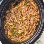 overhead photo of a slow cooker full of beef and noodles