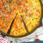 pinterest graphic of overhead of a frittata with a piece partially cut out, garnished with parsley and parmesan