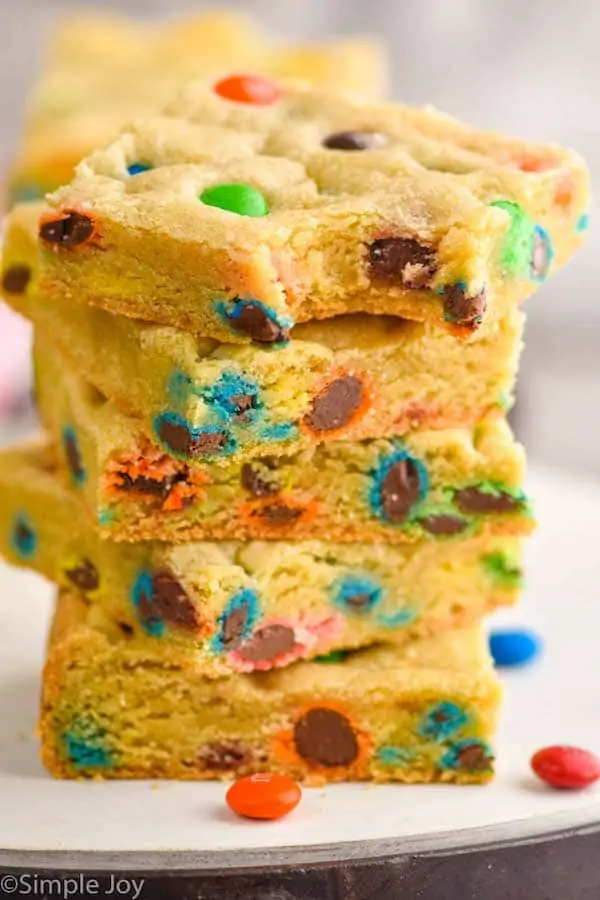 stack of five m&m cookie bars with the top one missing a bite