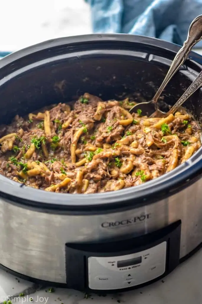 side view of a crockpot full of beef and noodles