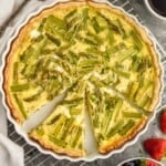overhead picture of an asparagus quiche that has pieces cut out - 9