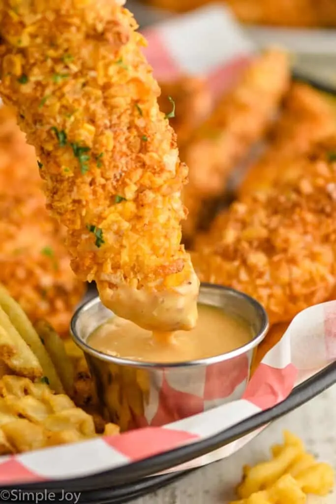 chicken strip being dipped into chick fil a sauce