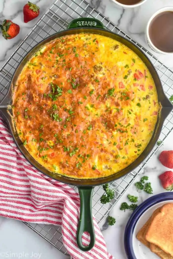 overhead photo of egg frittata in a skillet on a wire cooling rack