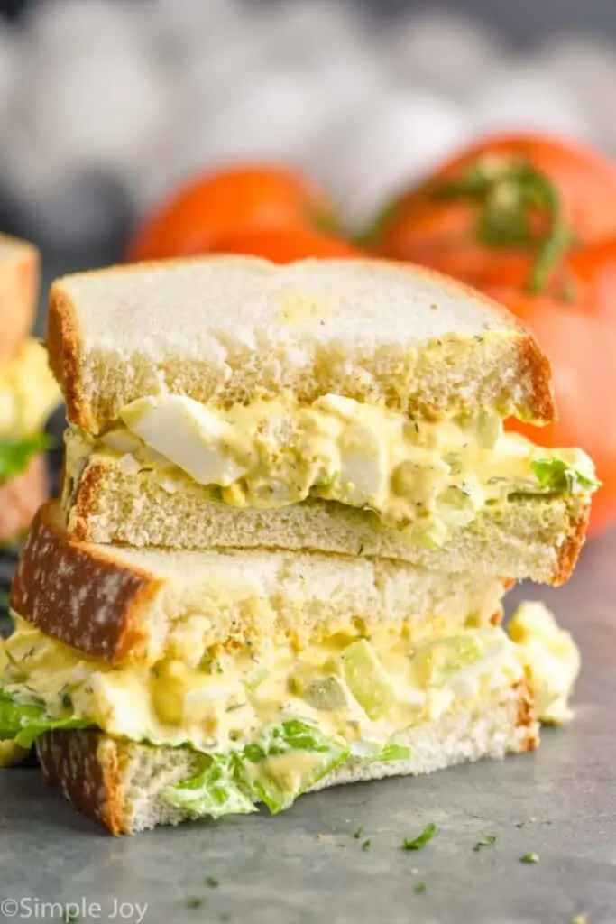 an egg salad sandwich that has been cut in half and stacked