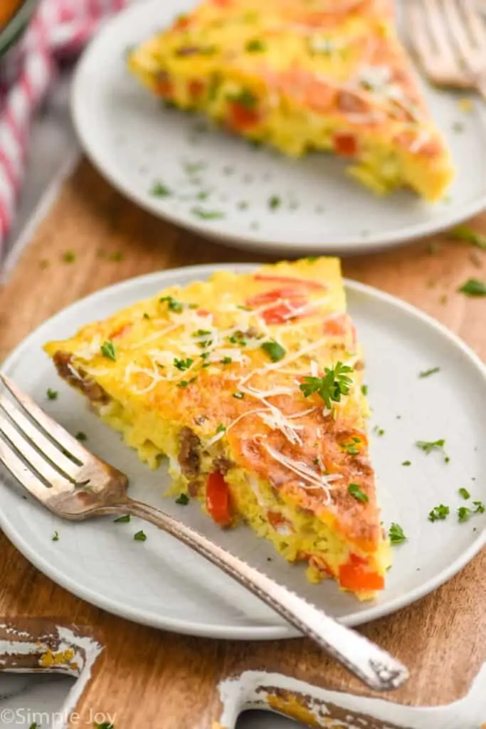 close up picture of a frittata recipe on a white plate garnished with parsley and parmesan