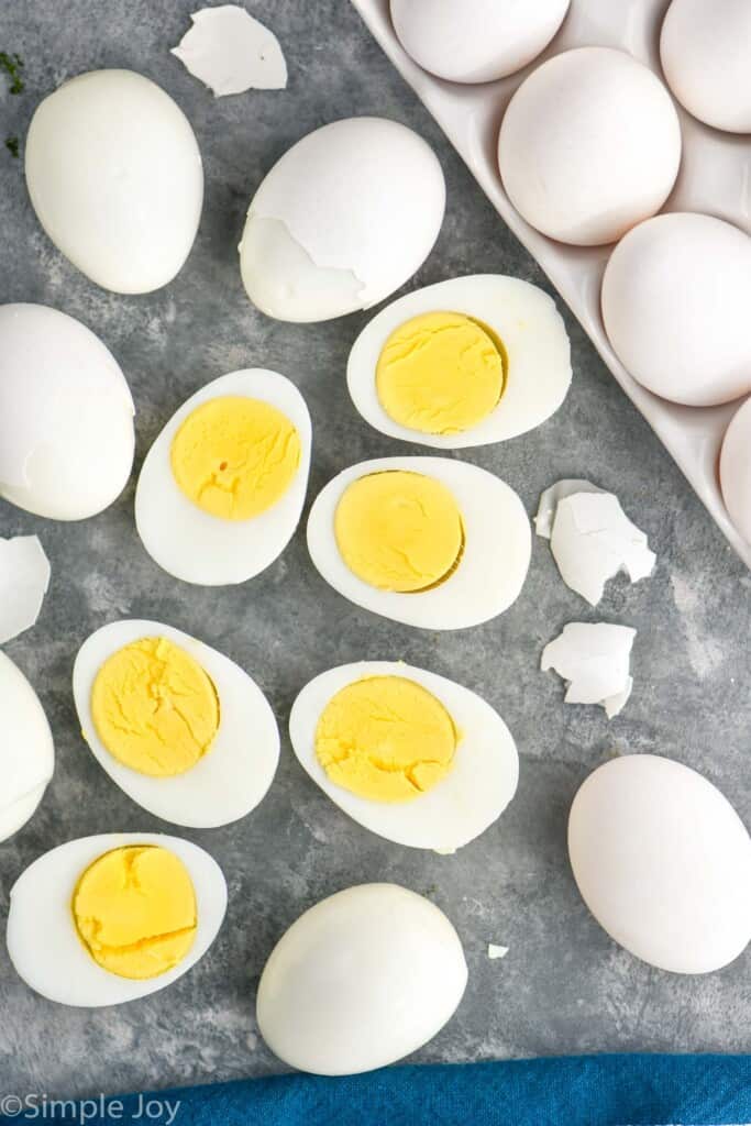 overhead view of instant pot hard boiled eggs, some cut in half and some in the process of being peeled