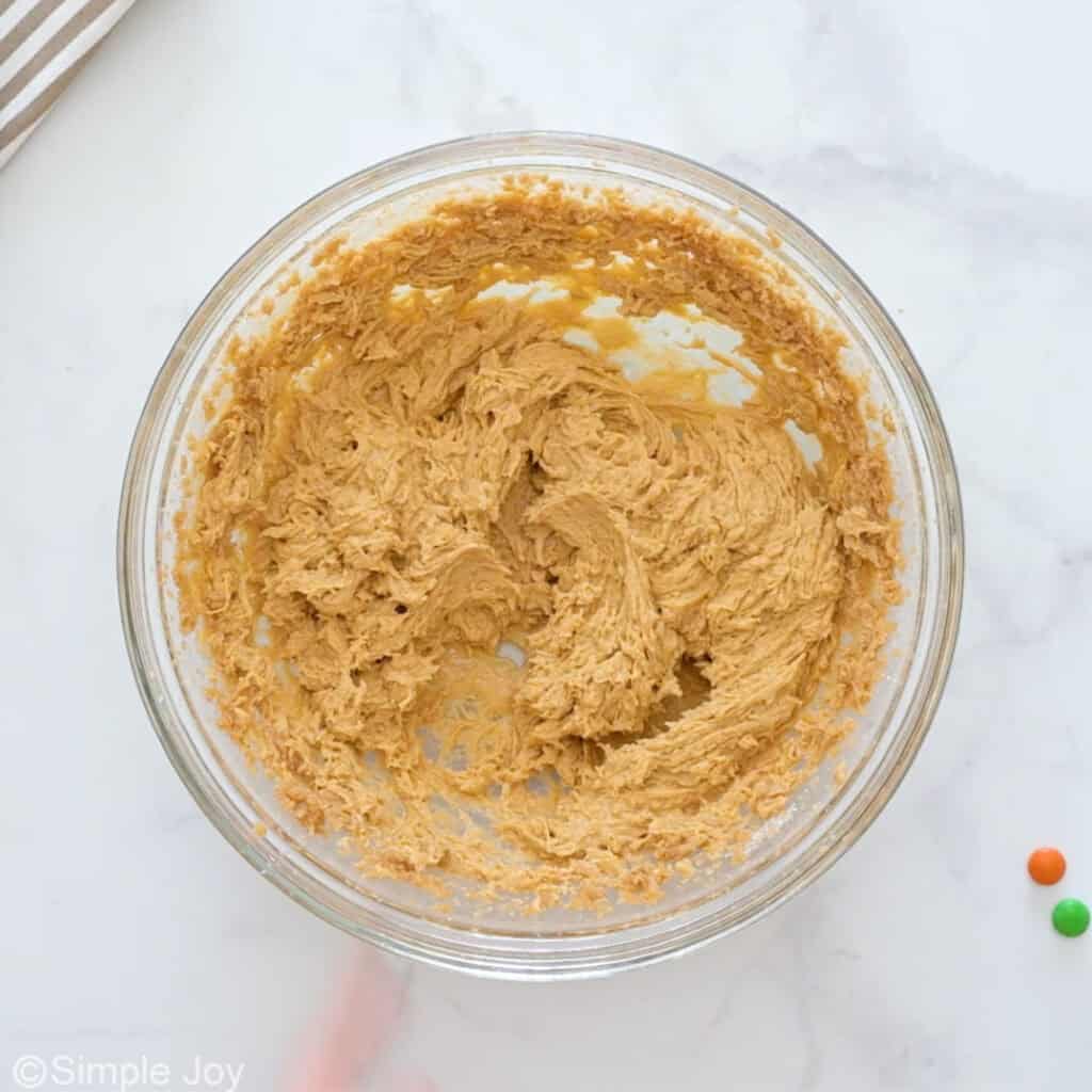 overhead of m&m cookie bar batter after adding vanilla and eggs