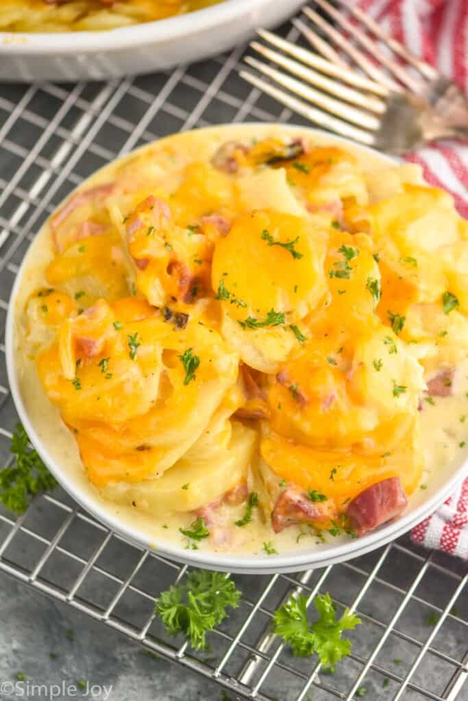 a plate of scalloped potatoes with ham and cheese