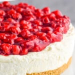 pinterest graphic close up of a cheesecake topped with cherries on a cake stand