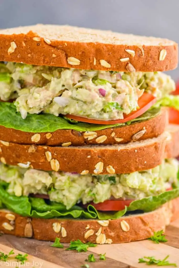 two avocado tuna salad sandwiches stacked one on top of the other