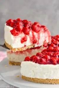 piece of cherry cheesecake being lifted out of a cheesecake