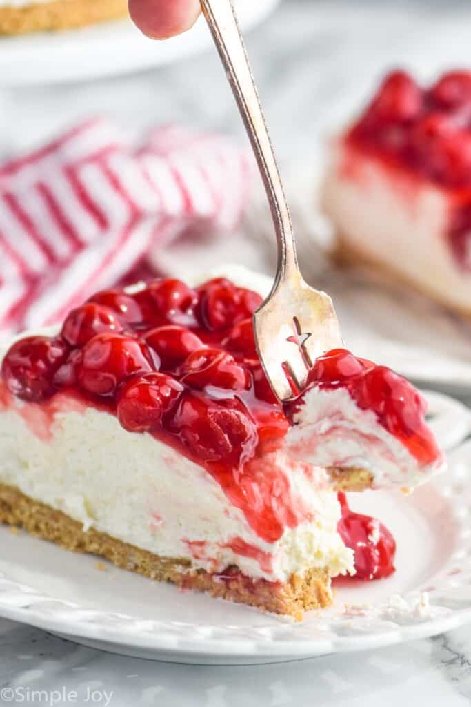 a fork taking a bite out of cheesecake