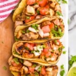 overhead of four street tacos on a board - 23