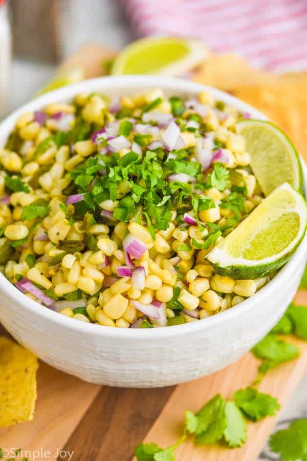 a white bowl full of chipotle corn salsa topped with extra cilantro