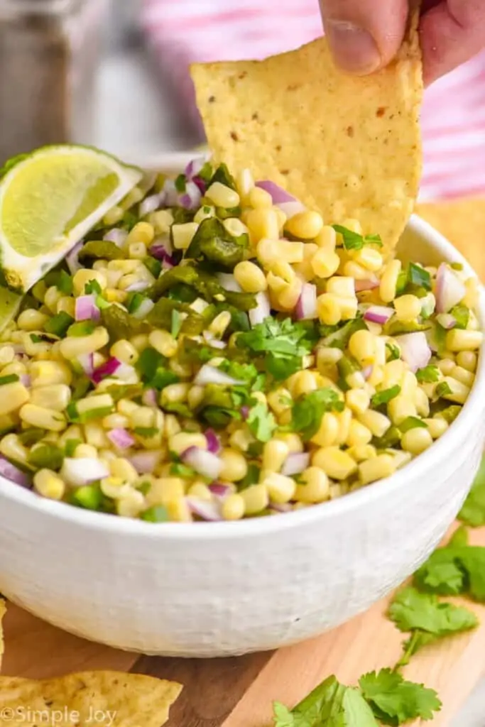 tortilla chip dipping into copycat chipotle corn salsa