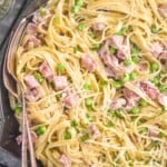 overhead close up view of ham and pea pasta in a skillet garnished with freshly grated parmesan cheese - 9