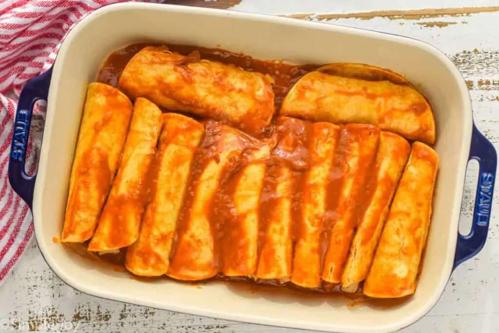 overhead of a baking dish filled with chicken enchiladas before being topped with cheese