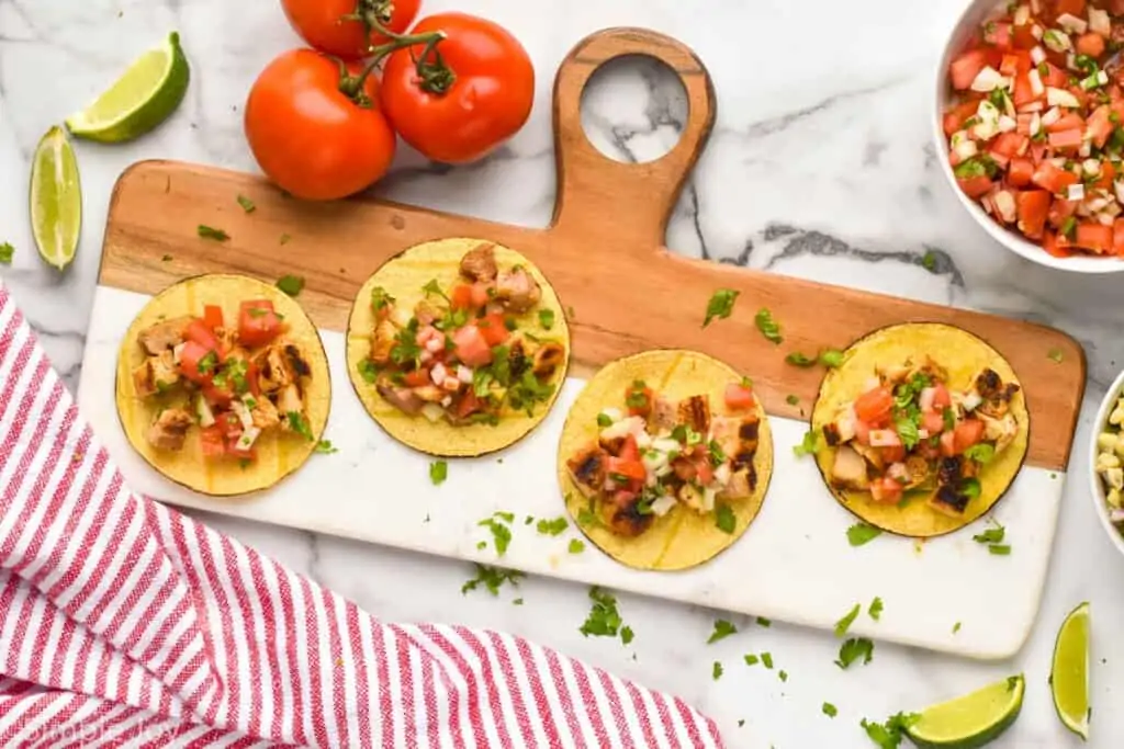 overhead of four Mexican street tacos on a platter