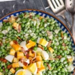 pinterest graphic of overhead of pea salad in a serving bowl with extra cheese, egg, and bacon on top