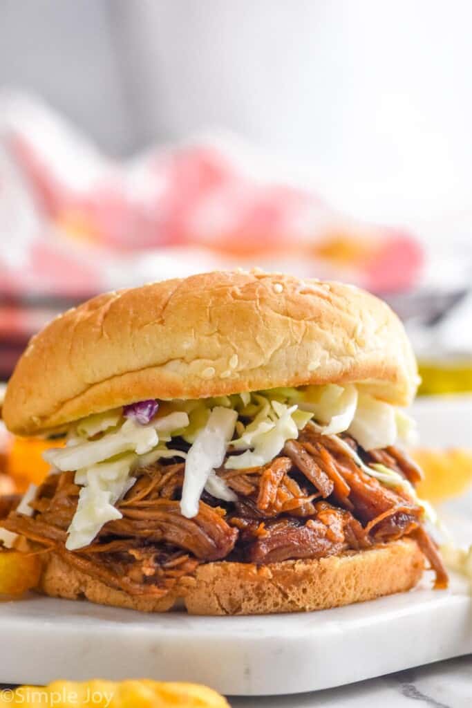 close up of a bbq pulled pork sandwich made in the slow cooker with coleslaw on it