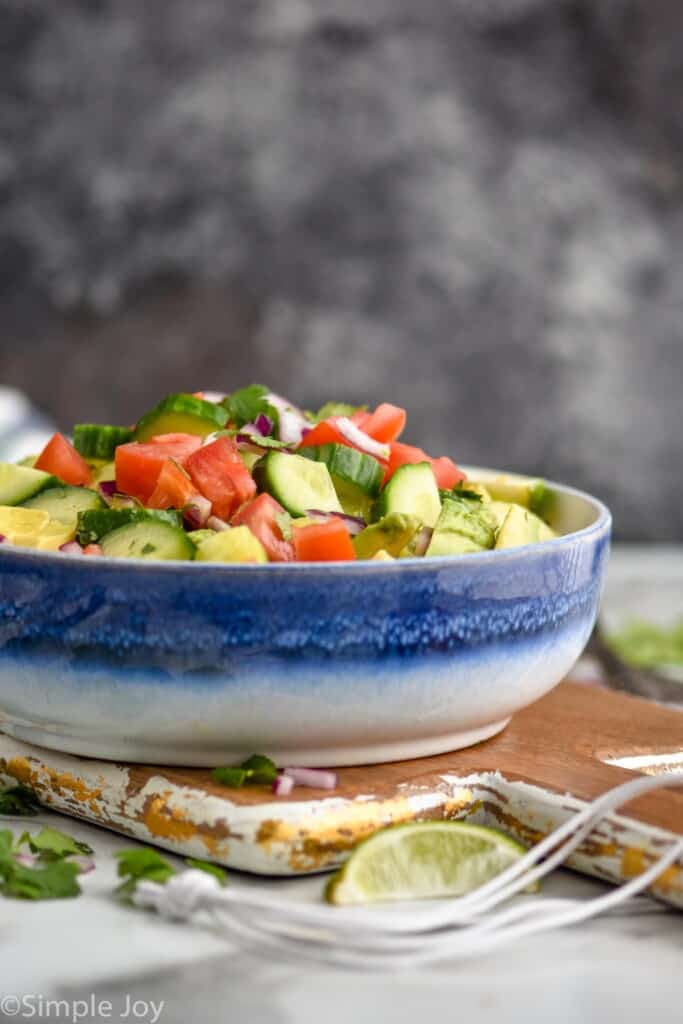 side view of a bowl of cucumber tomato avocado salad