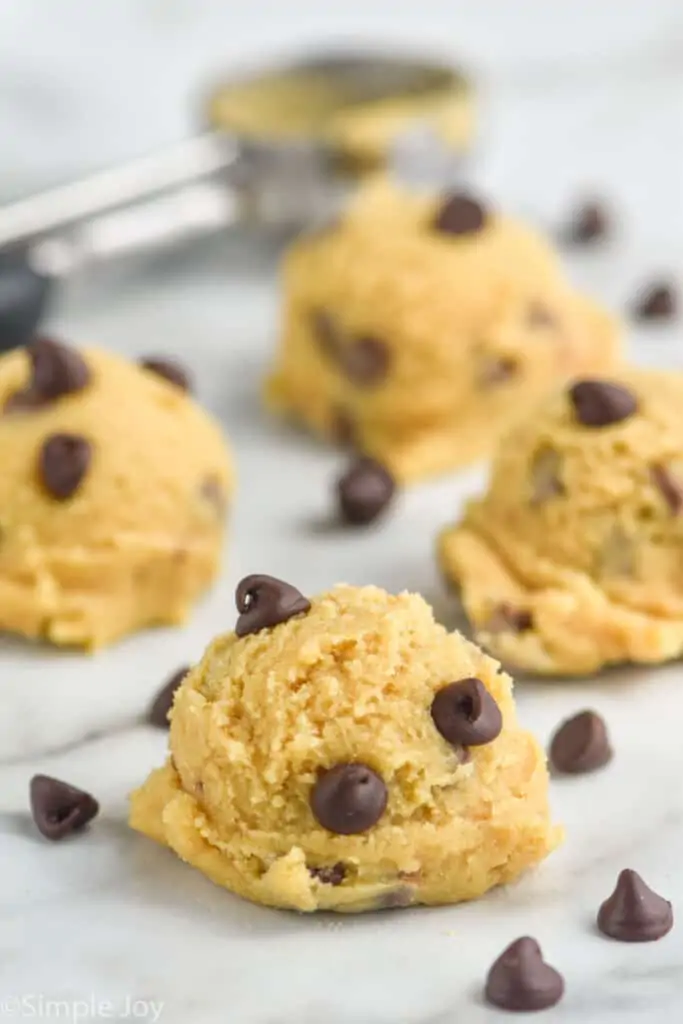 four scoops of edible cookie dough on a marble counter