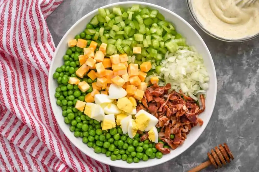 overhead of pea salad ingredients in a white bowl