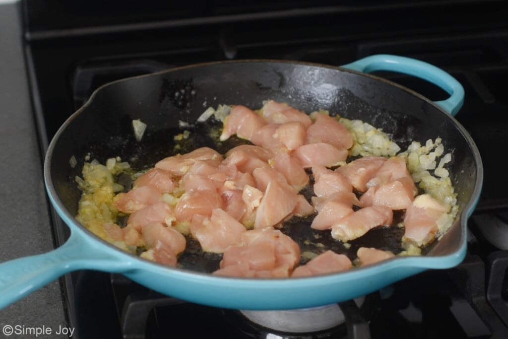 chicken pieces cooking in a frying pan
