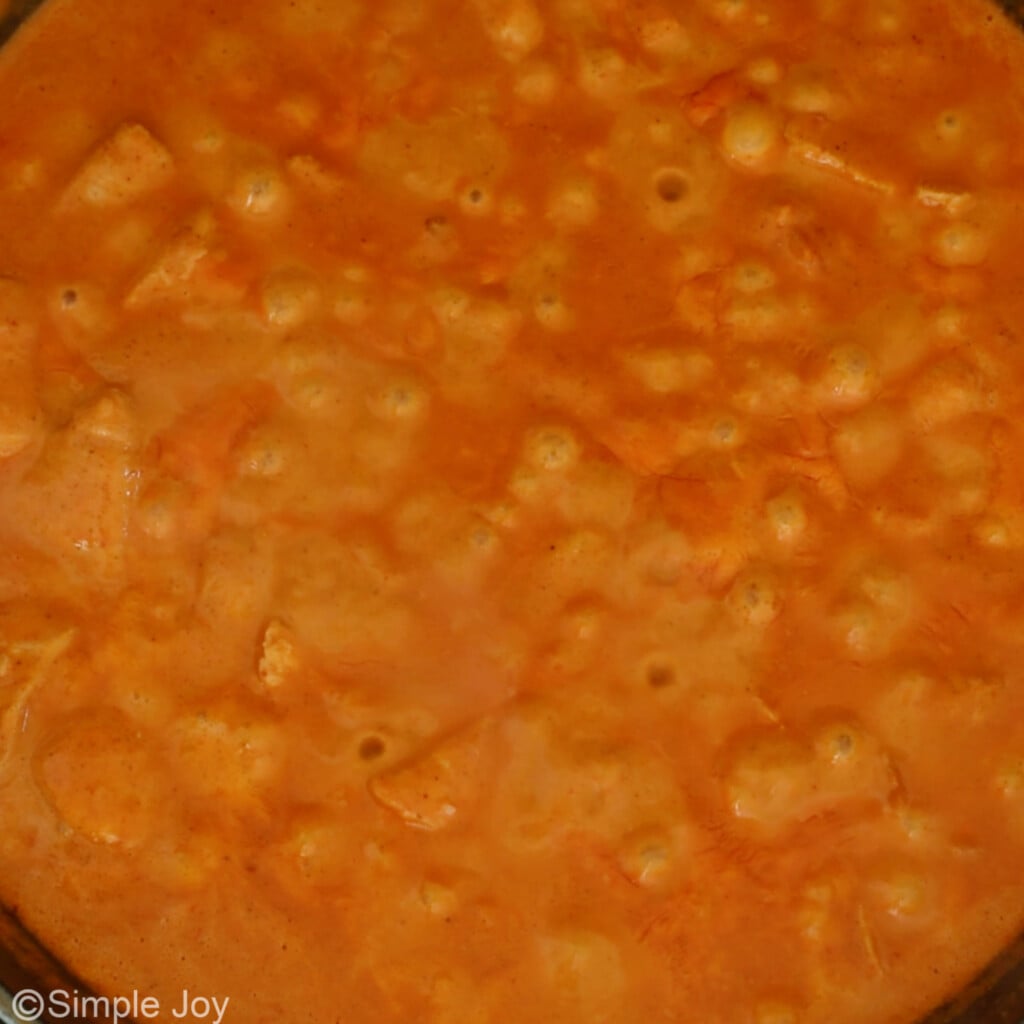 simmering a sauce to make butter chicken