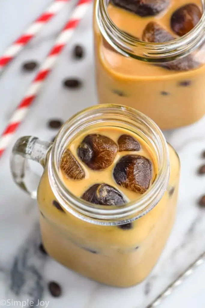 overhead of a mason jar mug filled with iced coffee and coffee ice cubes