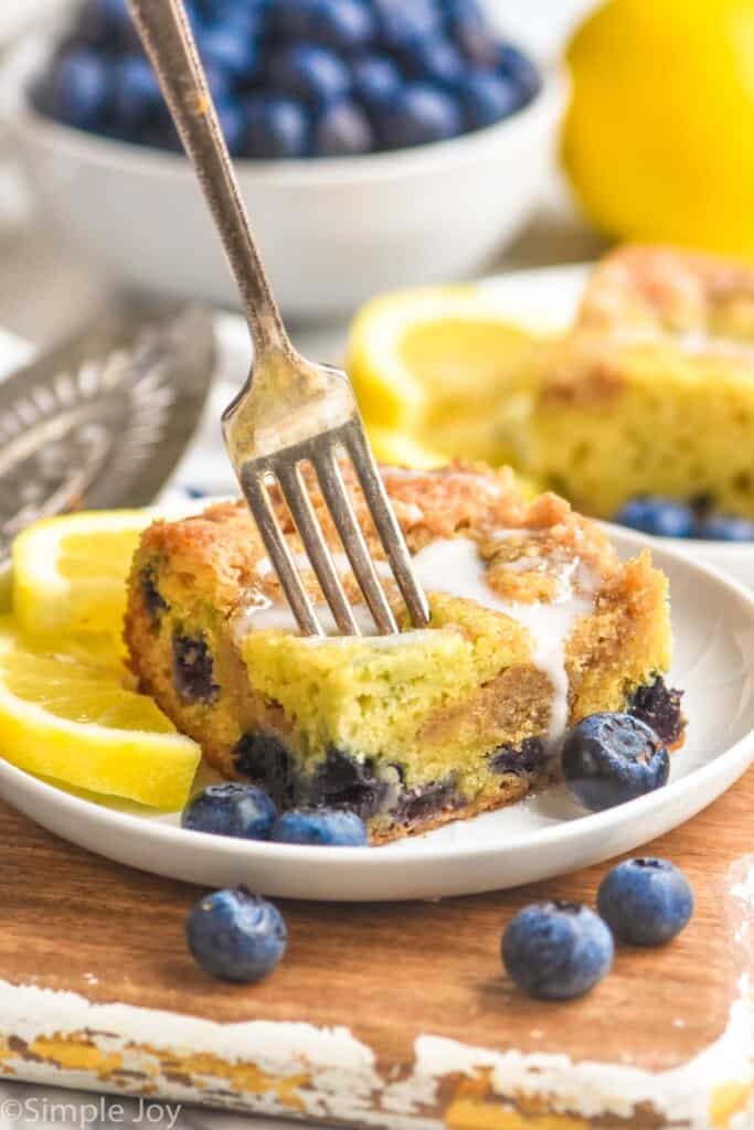 a piece of lemon blueberry coffee cake on a plate with a fork sticking out