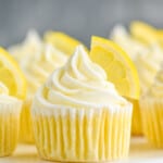 up close picture of lemon cupcakes topped with frosting swirl and a lemon wedge - 9
