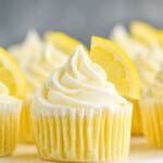 up close picture of lemon cupcakes topped with frosting swirl and a lemon wedge