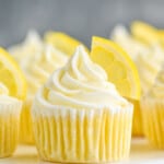 up close picture of lemon cupcakes topped with frosting swirl and a lemon wedge