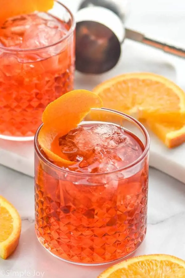 tumbler with Negroni recipe garnished with an orange peel