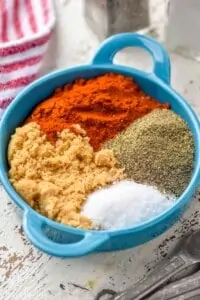 a small dish with paprika, brown sugar, salt, and pepper in it