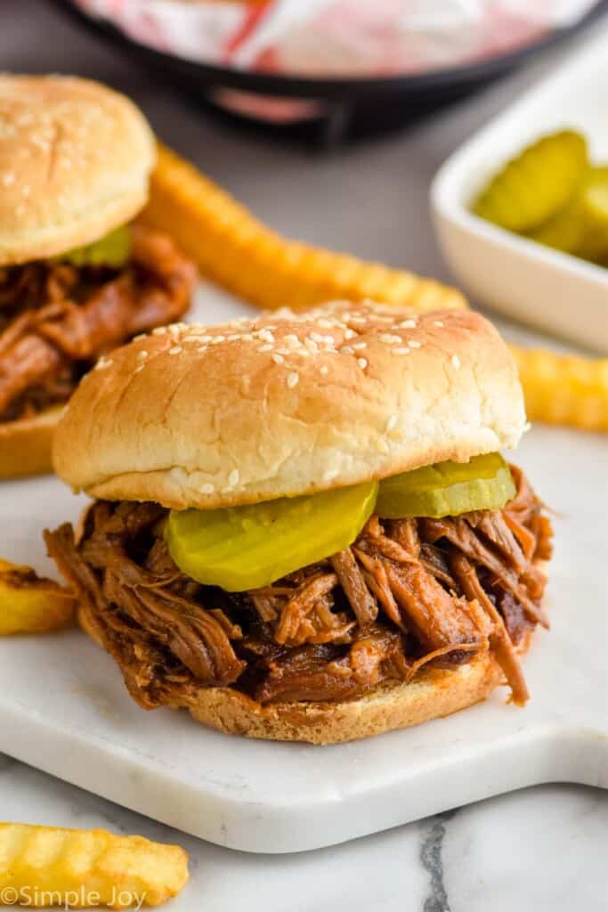 pulled pork sandwich with pickles on it