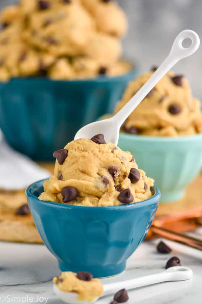 a small blue bowl with edible cookie dough and a spoon sticking out