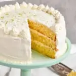 pinterest graphic of a whole key lime cake recipe on a cake stand with a piece missing