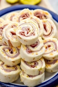 close up of ham and cheese roll ups on a plate