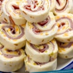 pinterest graphic of close up of ham and cheese roll ups on a plate
