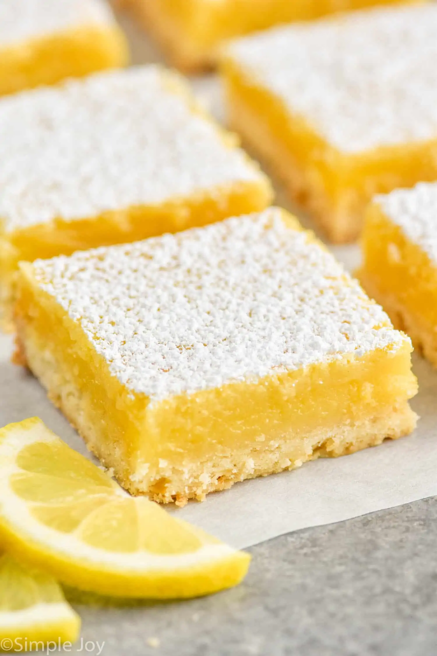 a close up of a lemon bar on parchment paper