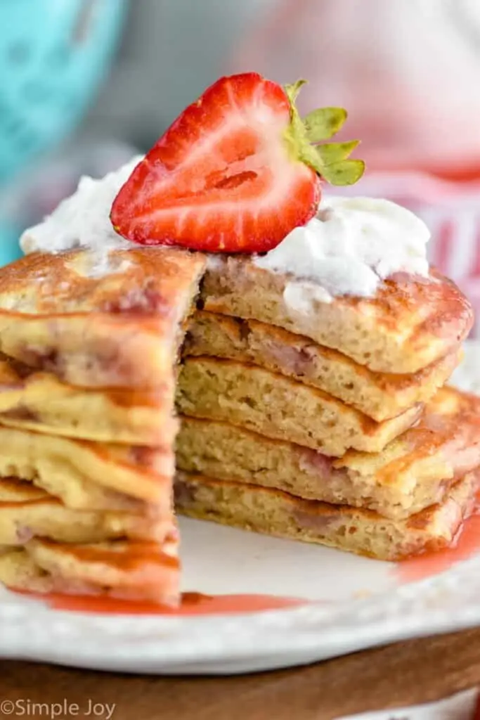 close up of strawberry pancakes with a slice missing