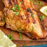 pinterest graphic of a chicken breast that has been marinated and then grilled on a cutting board garnished with parsley